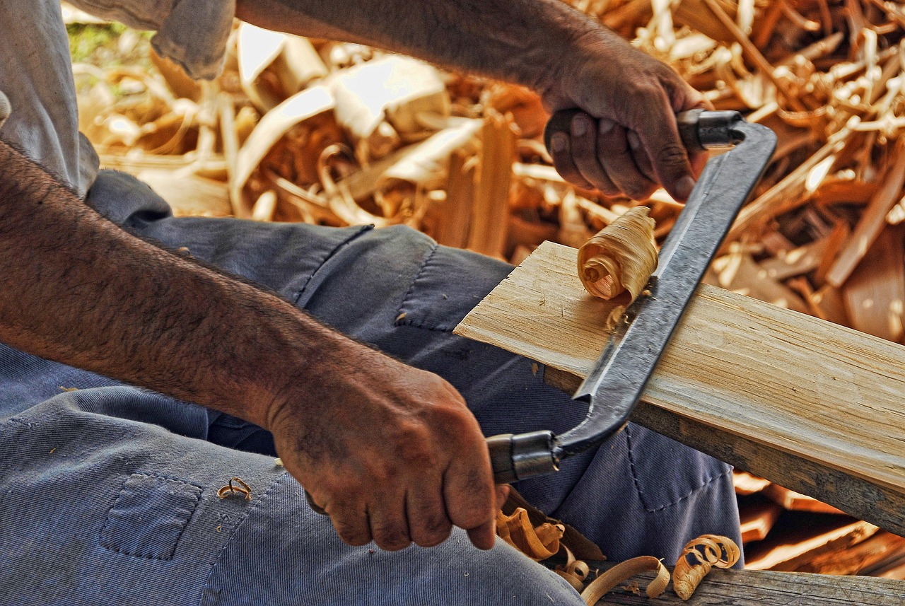 Hands shaving timber with a hand plane